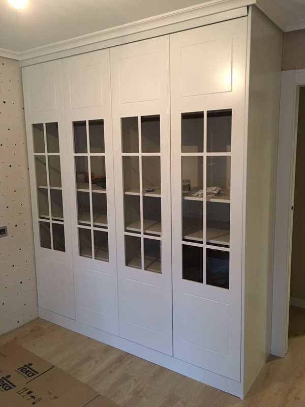 Mueble vitrina de cuatro puertas de suelo a techo con distribución interior a medida y cristales transparentes