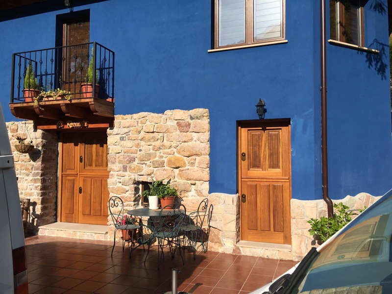 Puertas exteriores de madera maciza con cuarterones y acabado barnizado natural, diseñadas e integradas respetando el carácter y el patrimonio arquitectónico de la vivienda